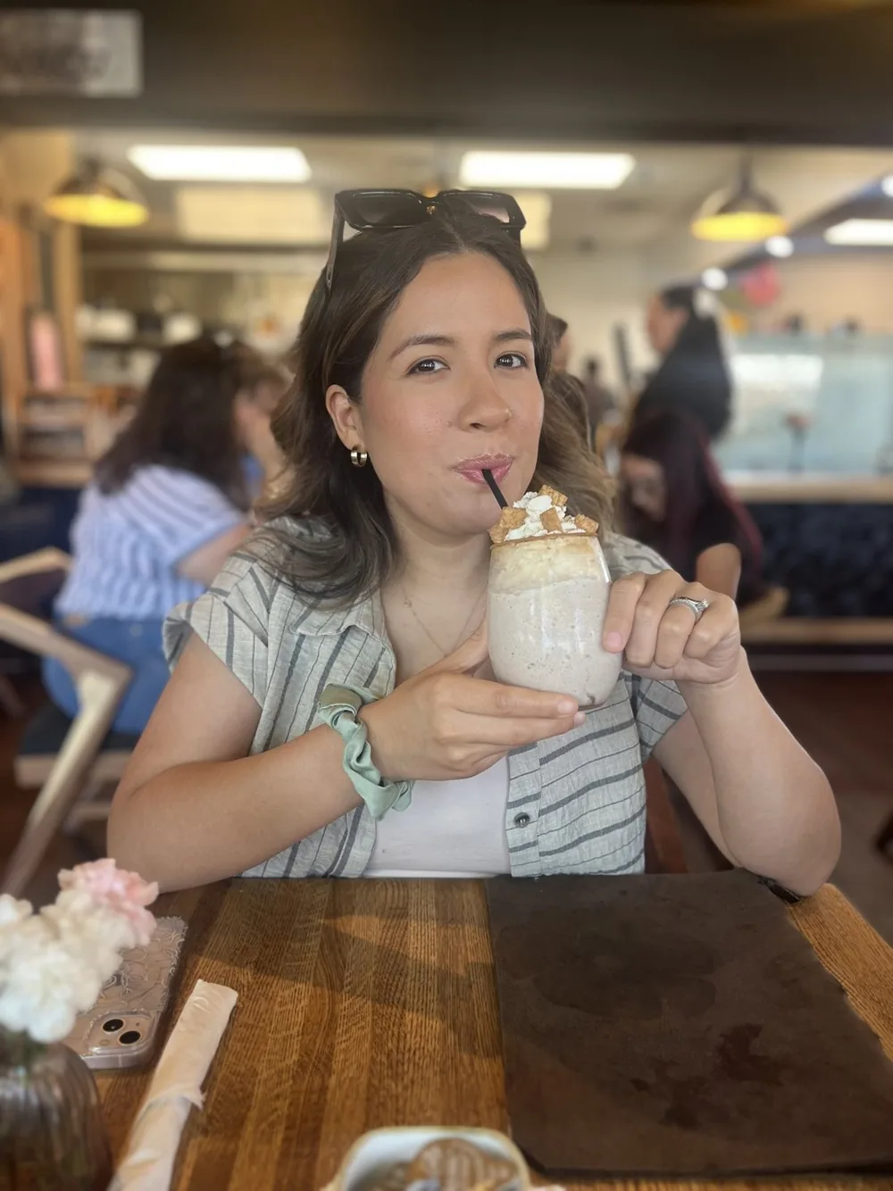 Desiree sipping a milkshake at a restaurant table